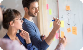 Deux personnes travaillant devant un tableau